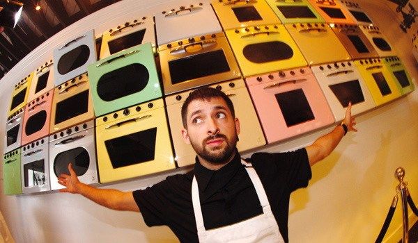 Johnny Cupcakes founder John Earle in front of his Los Angeles' shop's wall of ovens.