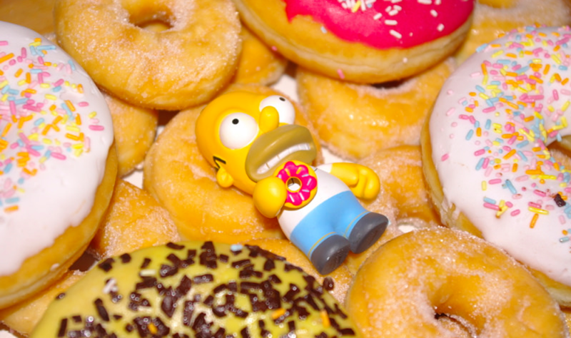 Homer Simpson toy sitting on donuts